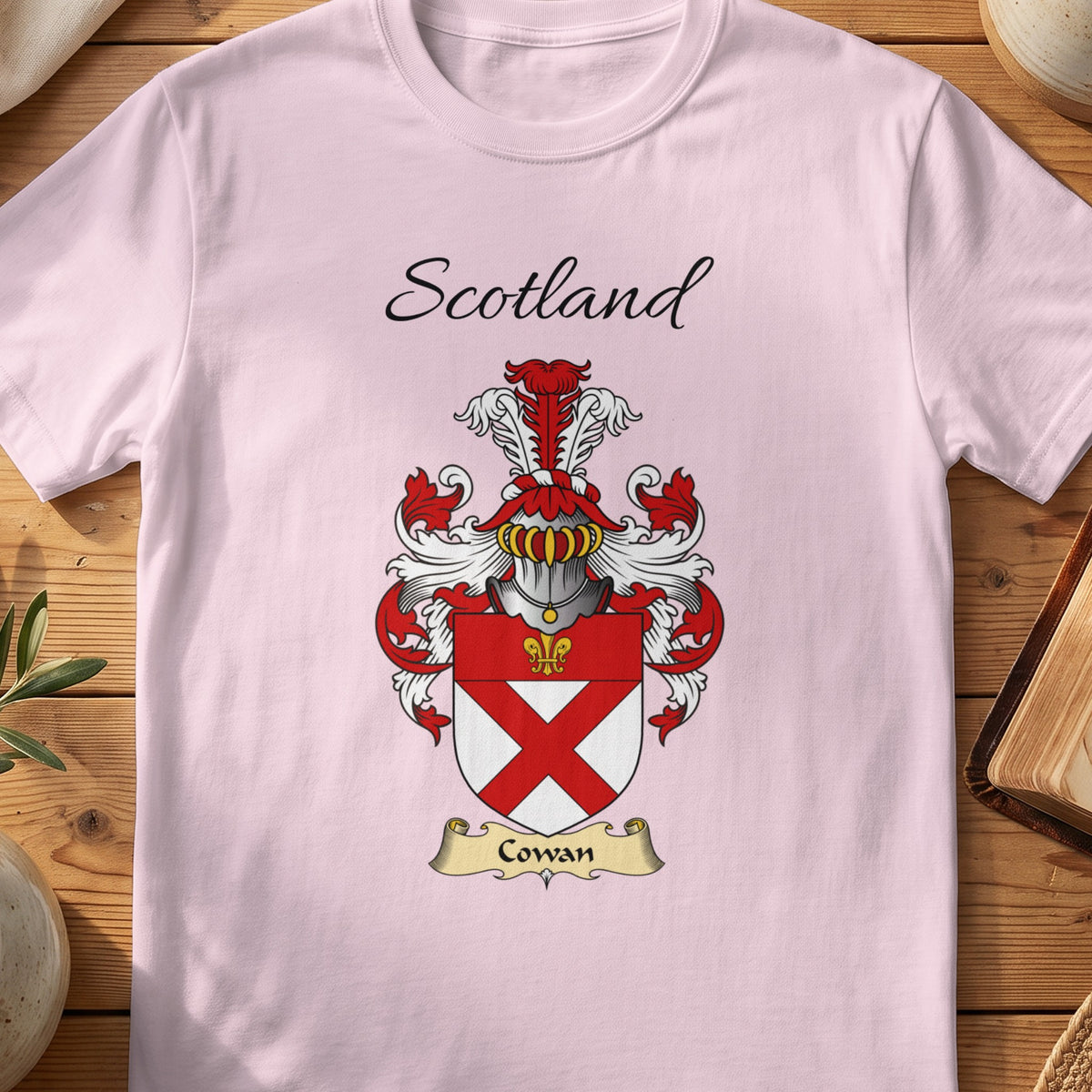 Light Pink Cowan Scottish family shield T-shirt featuring a red diagonal cross beneath a red top band