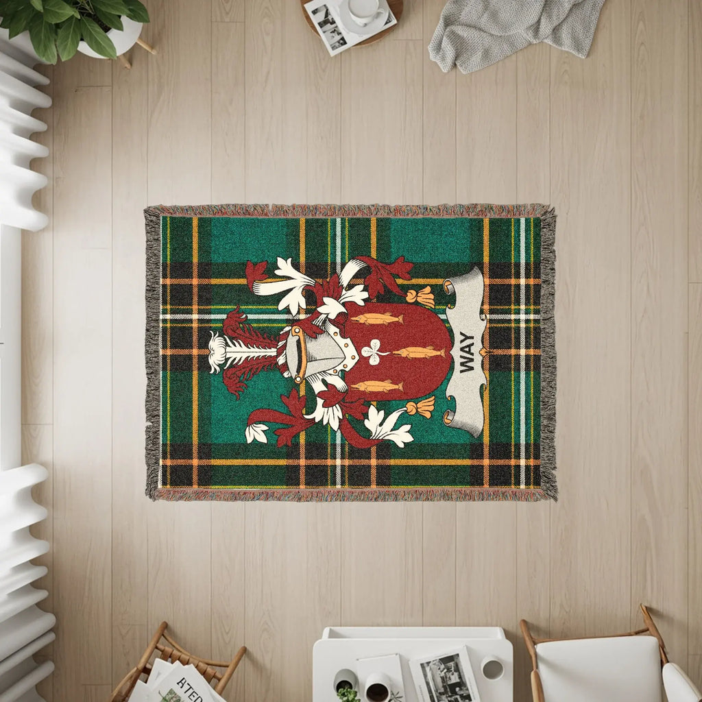 Woven blanket with a green tartan plaid and a coat of arms featuring a banner reading "WAY".