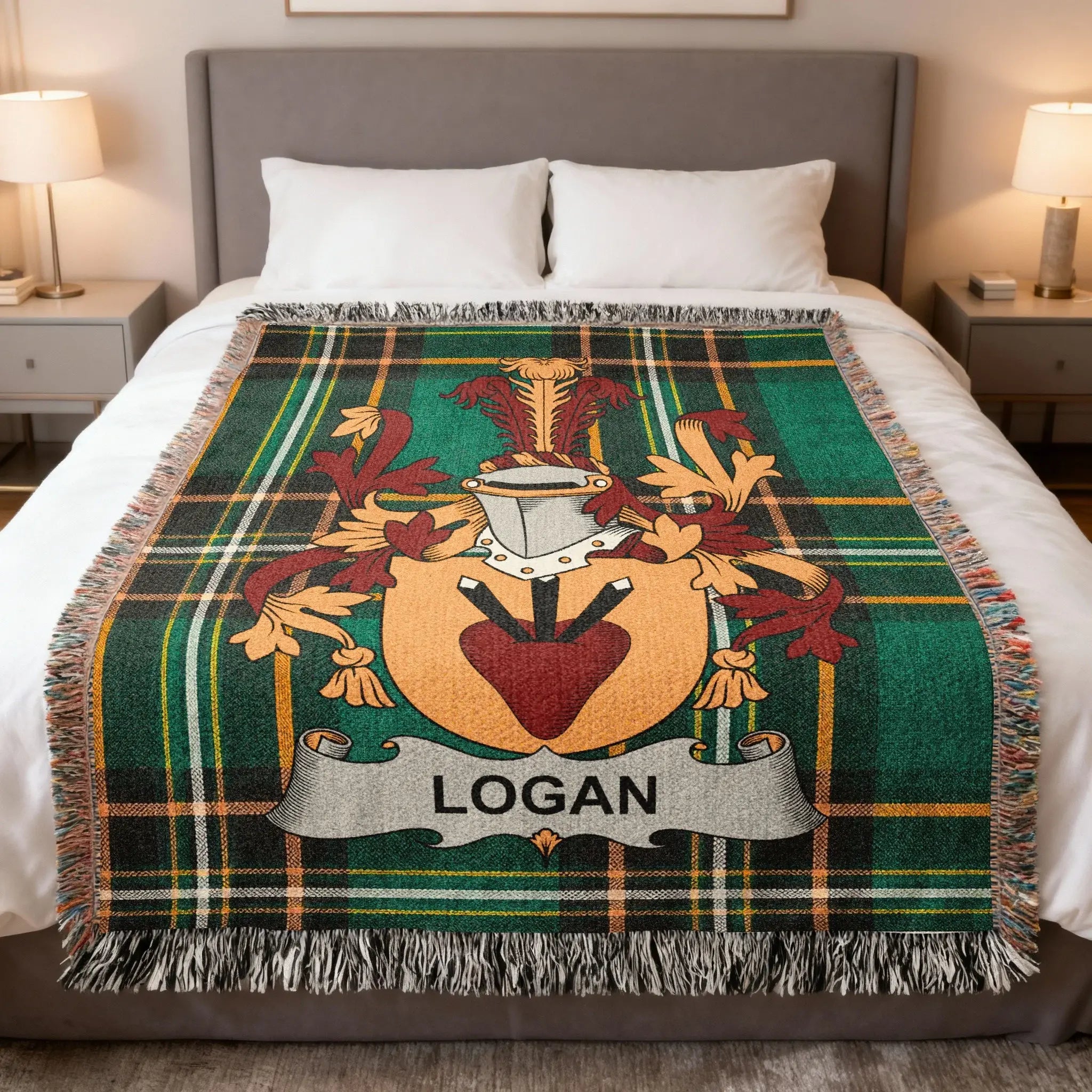Green tartan blanket with Logan crest, draped on a bed.