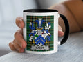 Mug with the Bagot family crest on a plaid background.