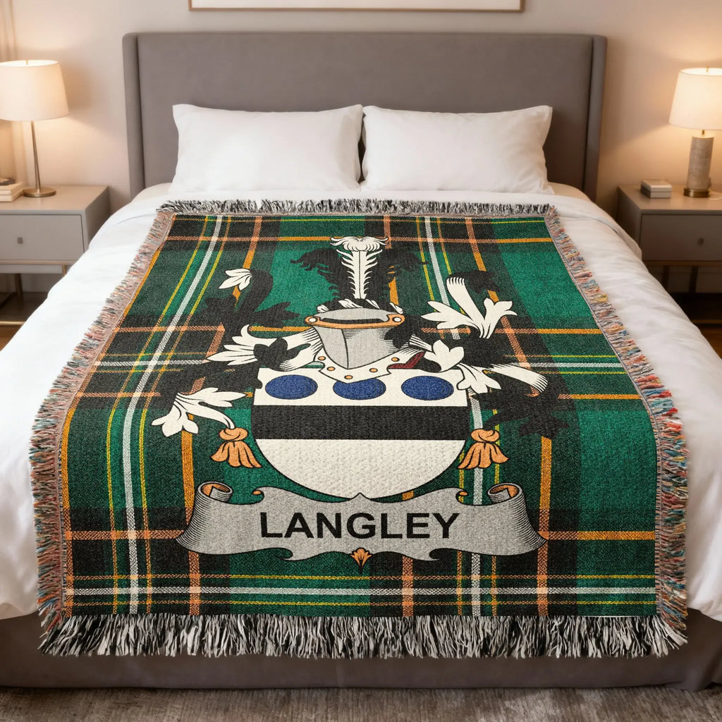 Tartan blanket with Langley family crest on a bed.