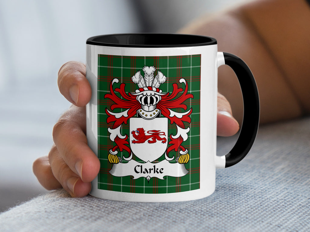 White mug with black handle featuring the Clarke family crest on a green tartan background.