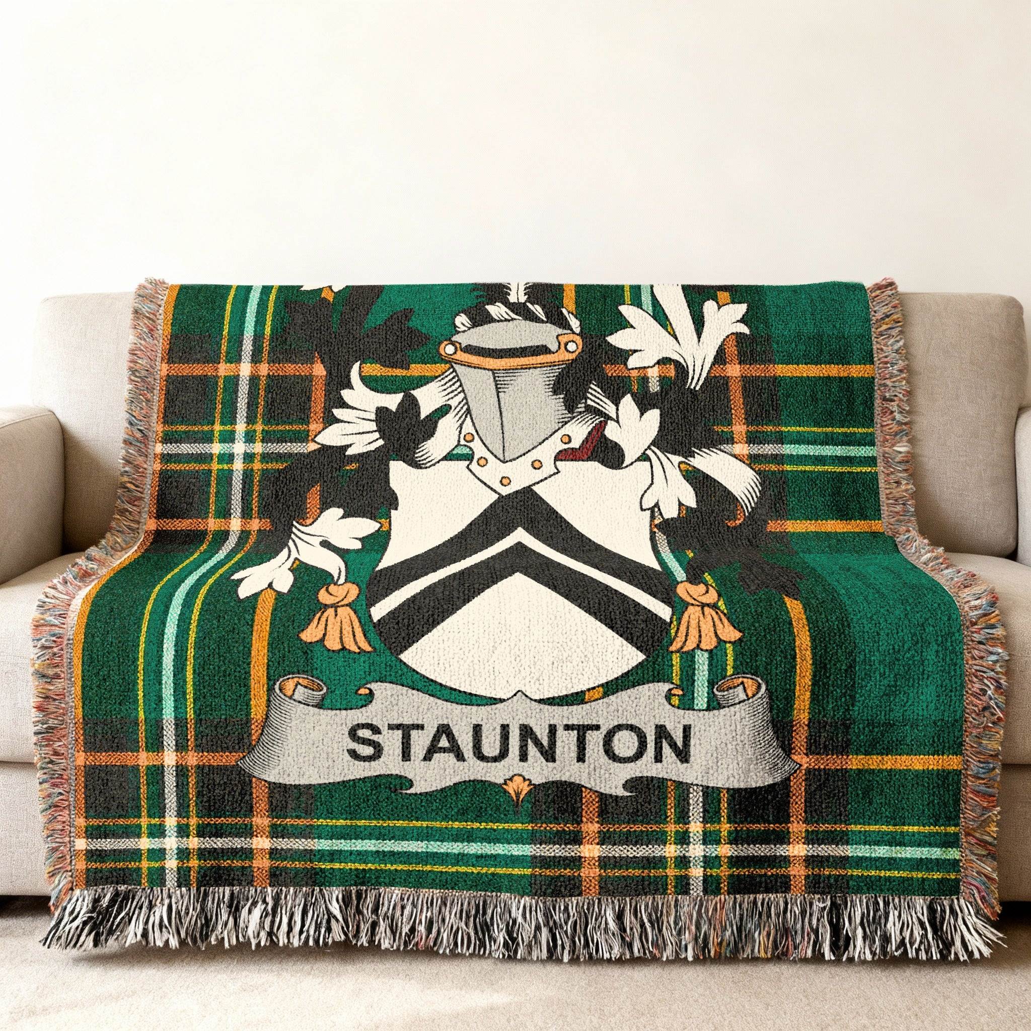 Green tartan throw blanket with a coat of arms and "STAUNTON" banner.