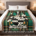 Fitz-Rice tartan blanket with coat of arms draped on a bed.