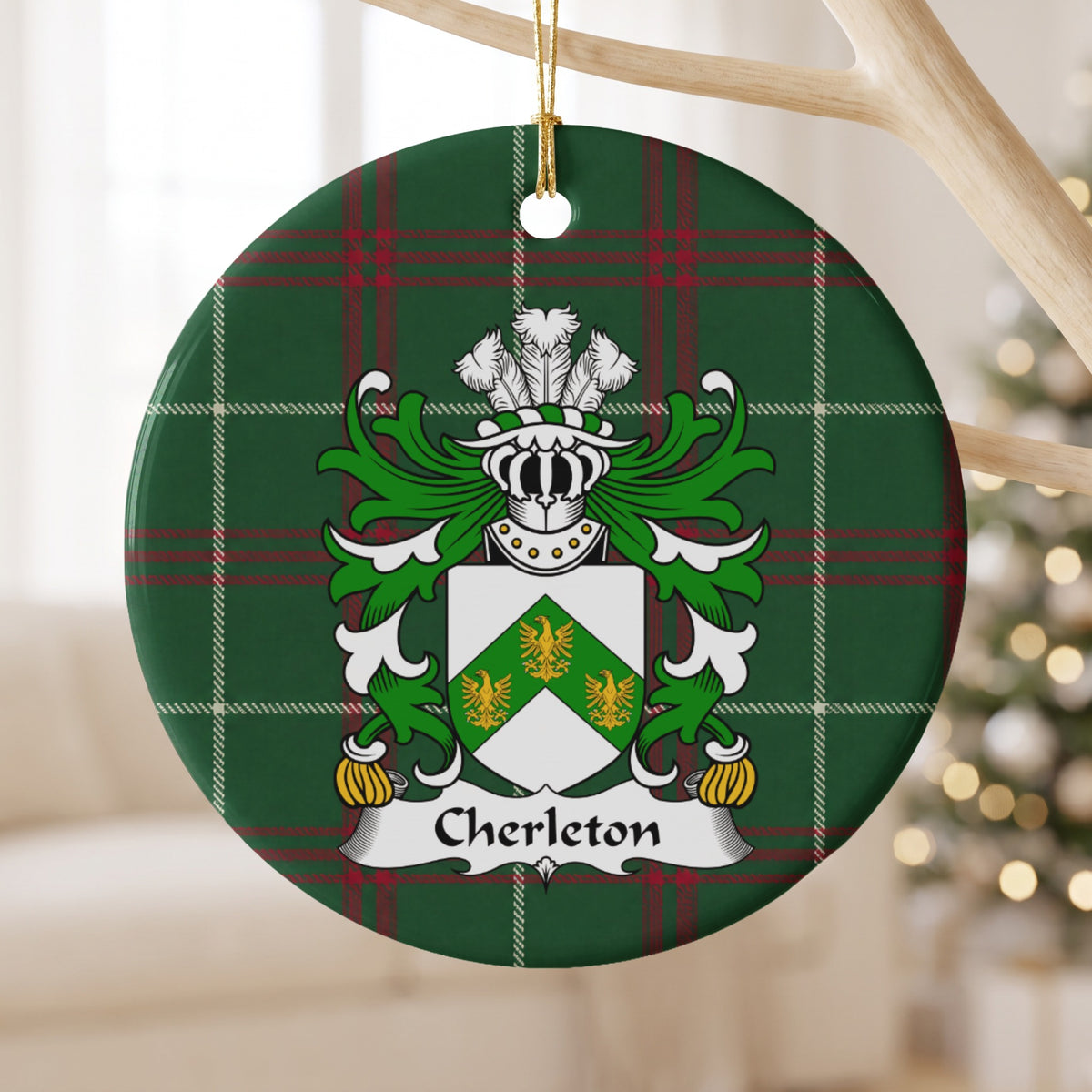 Cherleton ornament hanging from a pale wooden branch; three gold birds on a green chevron across a white shield on Welsh national tartan.