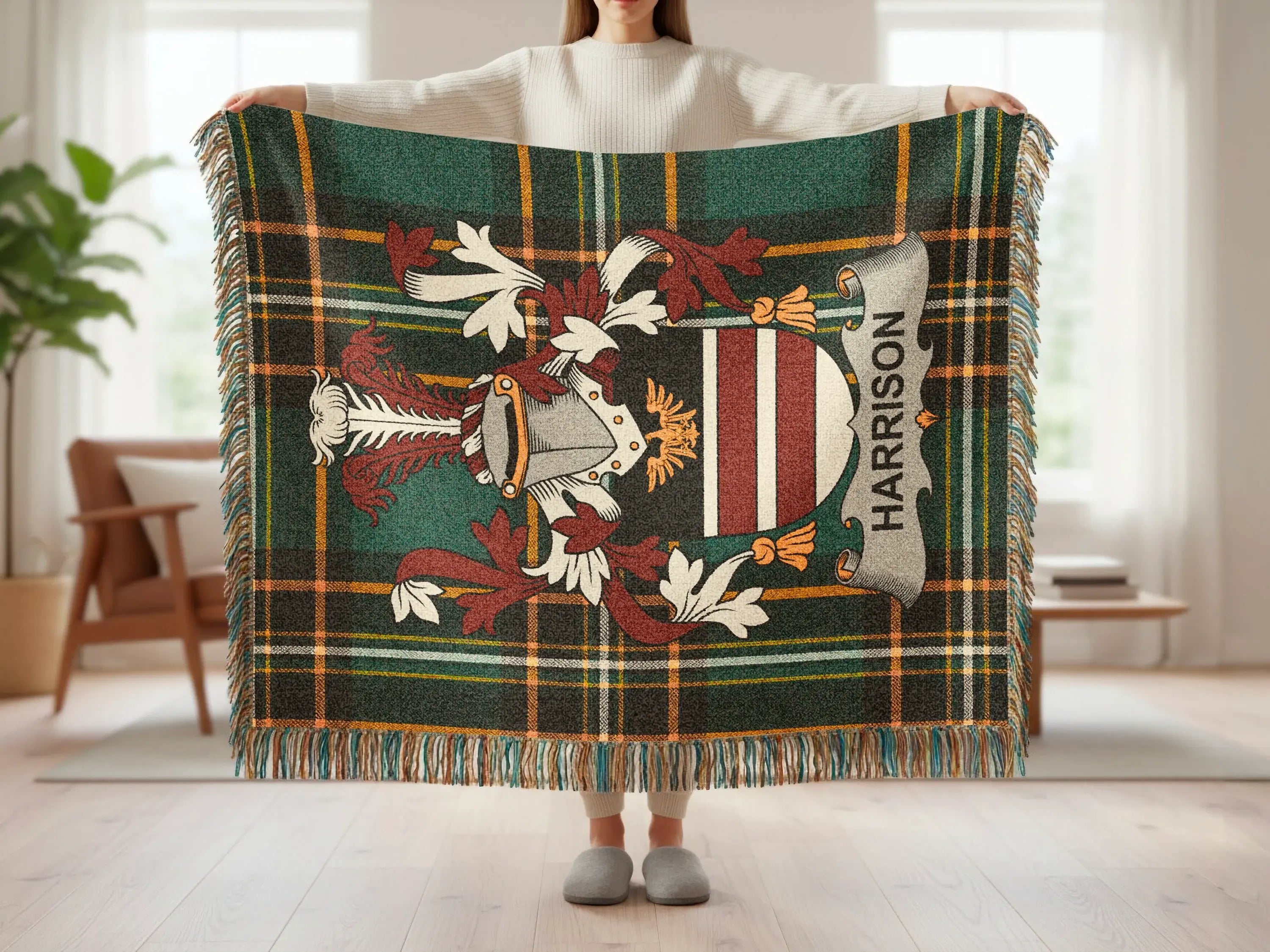 Tartan blanket with a crest and "Harrison" text, held by a person.