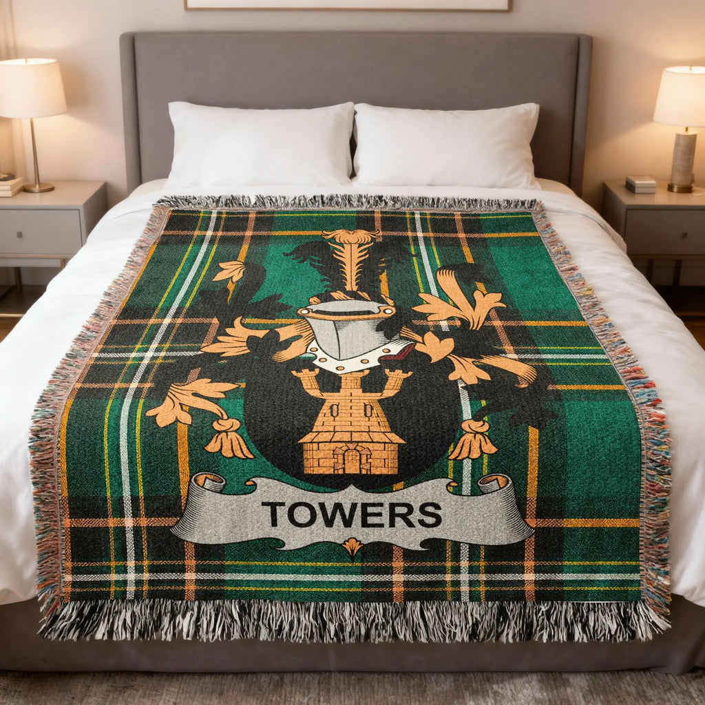 Green plaid blanket with a crest and "TOWERS" banner on a bed.