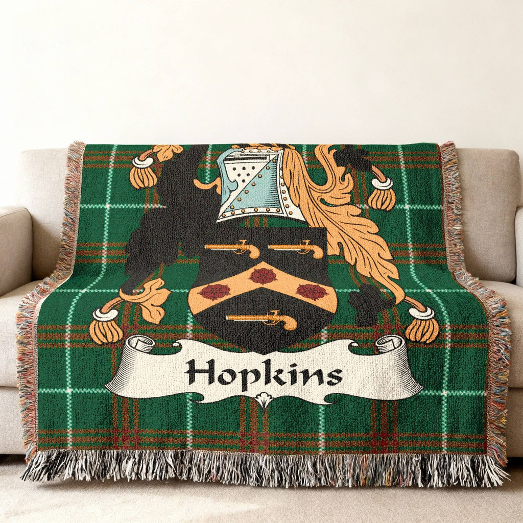 Hopkins family crest woven throw blanket with green plaid background.
