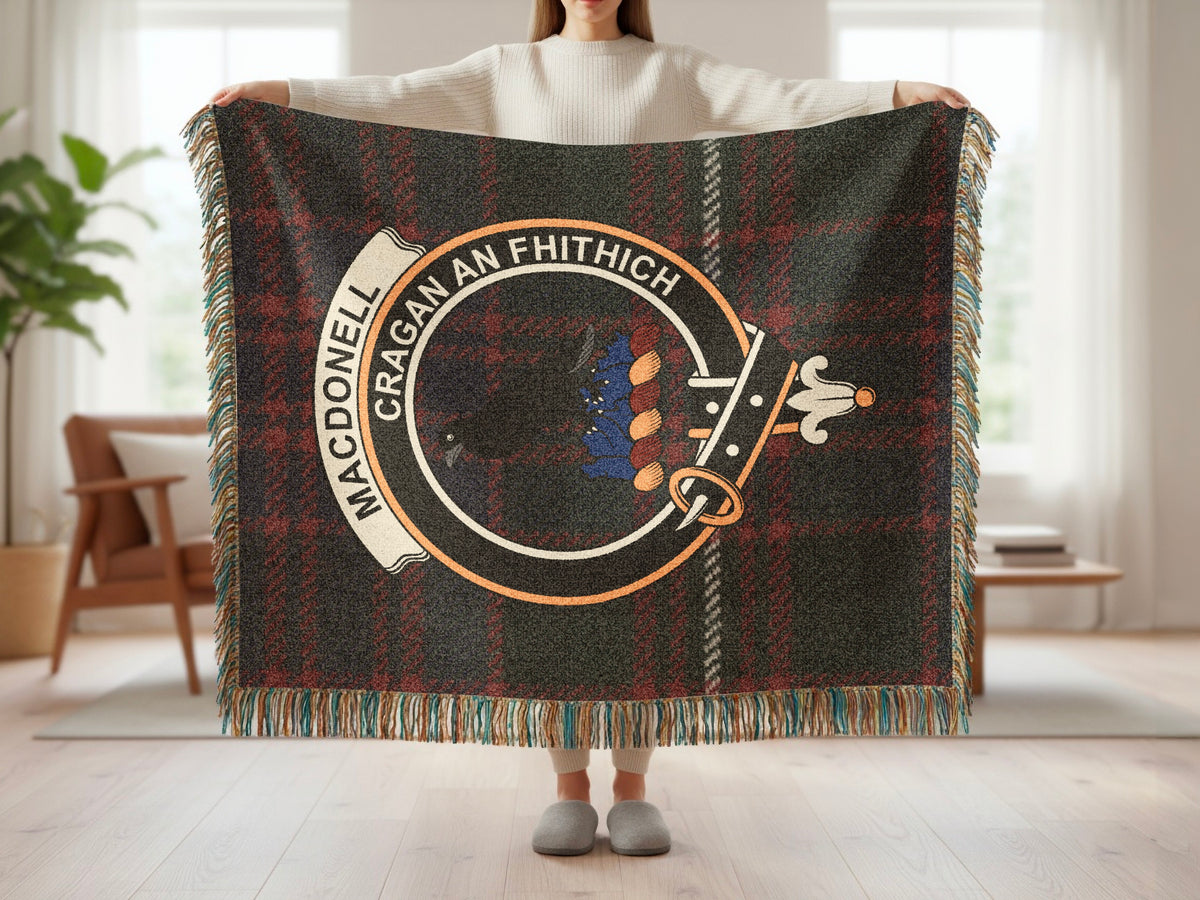 Person holding the MacDonell of Glengarry woven blanket to show the full design, tartan background and fringe