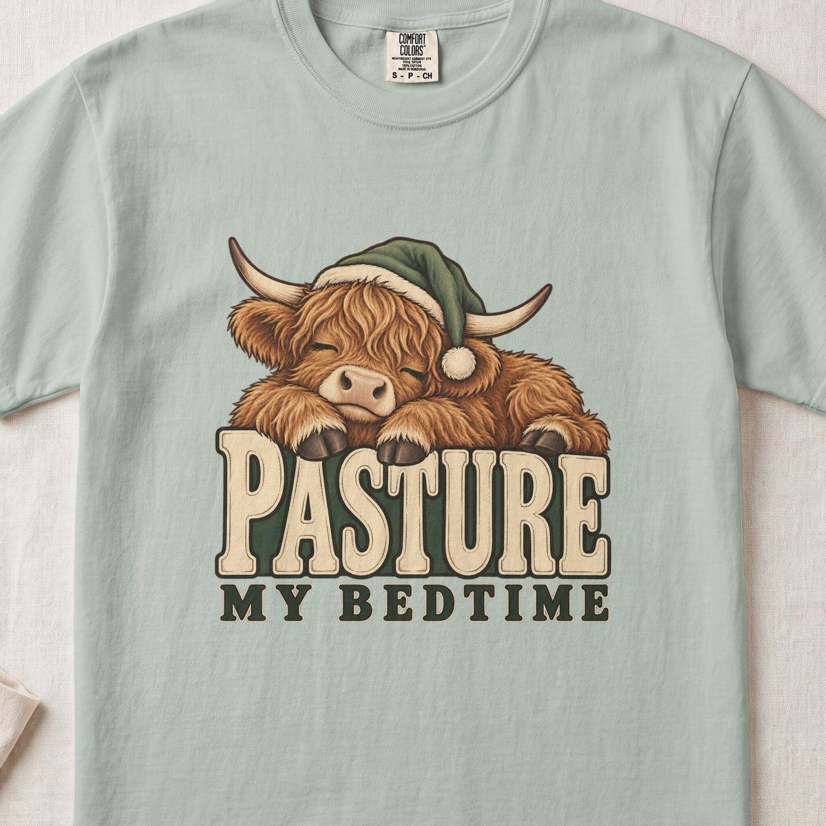 Pasture My Bedtime Highland cow design on a Bay Comfort Colors 1717 T-shirt, flat lay