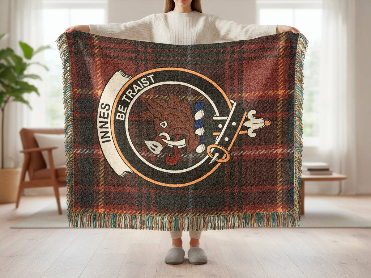 Person holding the Innes woven blanket to show the full design, tartan background and fringe