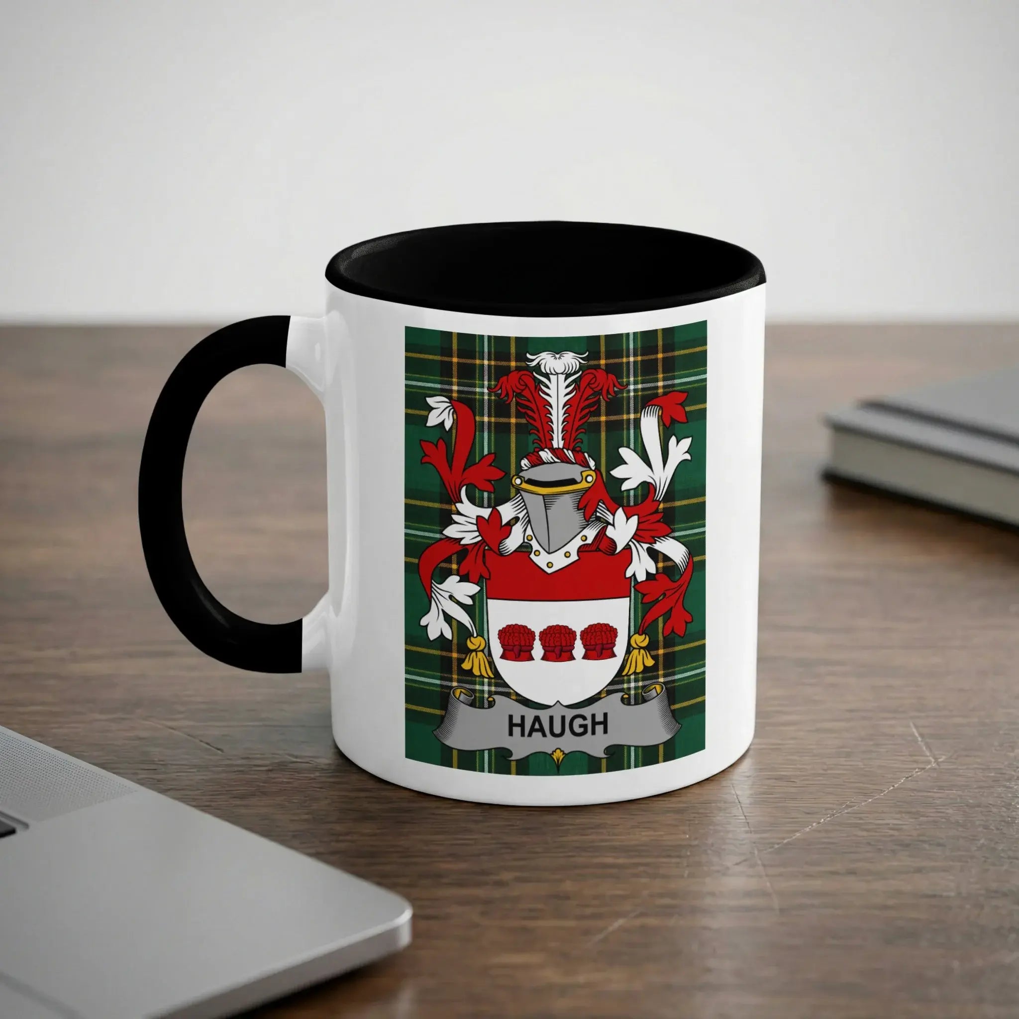 White mug with black handle, featuring the Haugh family crest on a tartan background.