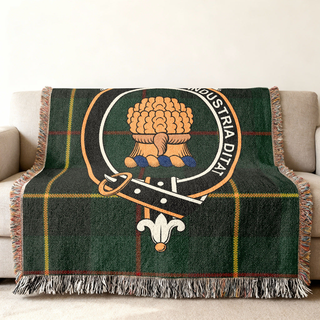 Close view of the Wauchope woven blanket draped over a sofa, showing the crest and fringed edges