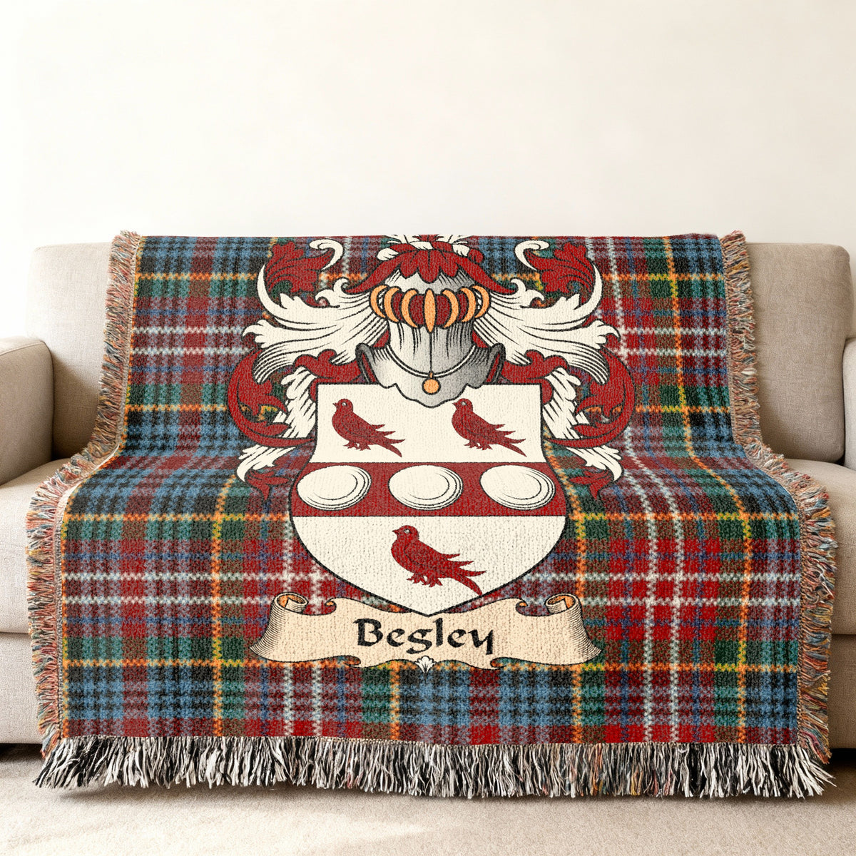 Begley Scottish family shield woven blanket with Caledonia tartan background on a sofa