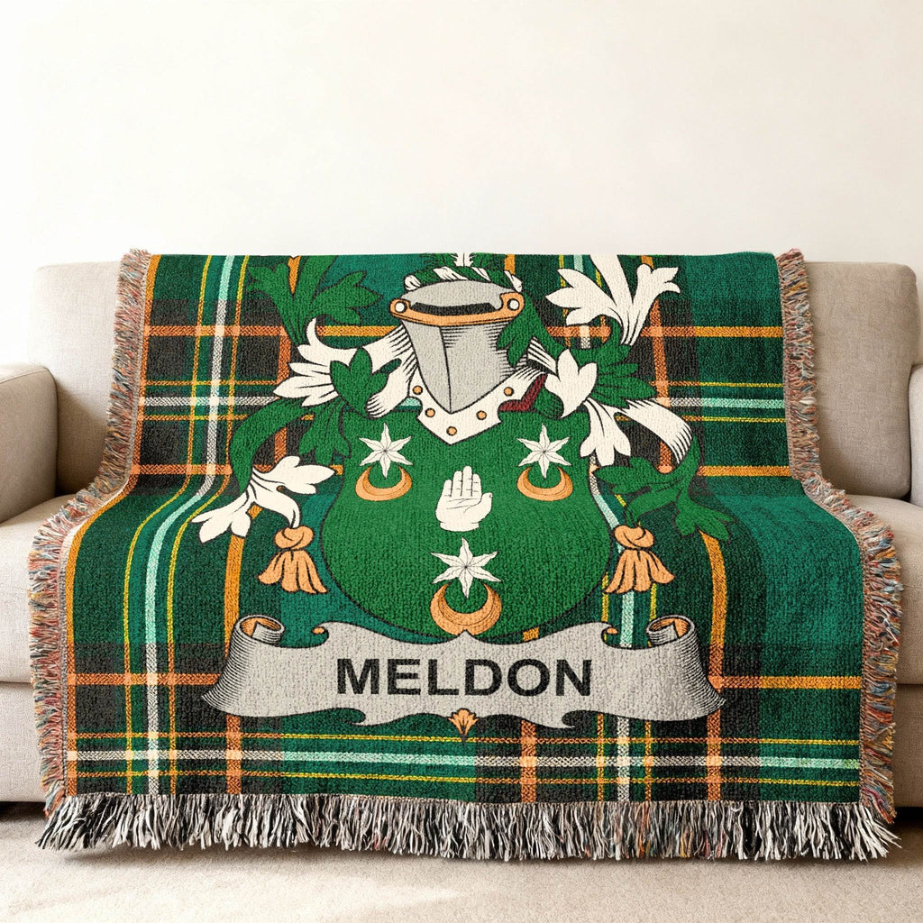 Green plaid blanket with a shield emblem and MELON banner on a sofa.