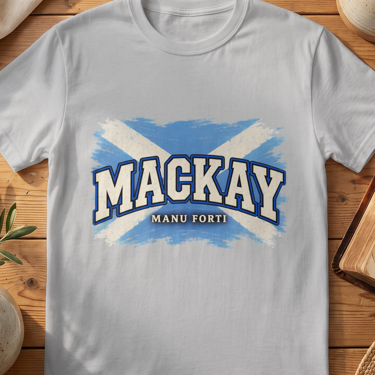 MacKay Scottish Saltire T-shirt in Sport Grey, with distressed blue and cream flag and “Manu Forti” lettering.