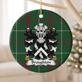 Broughton ornament hanging from a pale wooden branch; a white chevron between three white owls on black on Welsh national tartan.