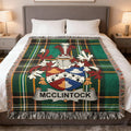 McClintock tartan blanket with family crest on a bed.