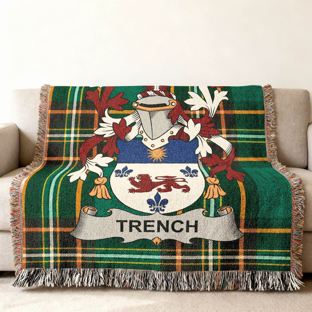 Trench family crest on a green tartan throw blanket with fringe.
