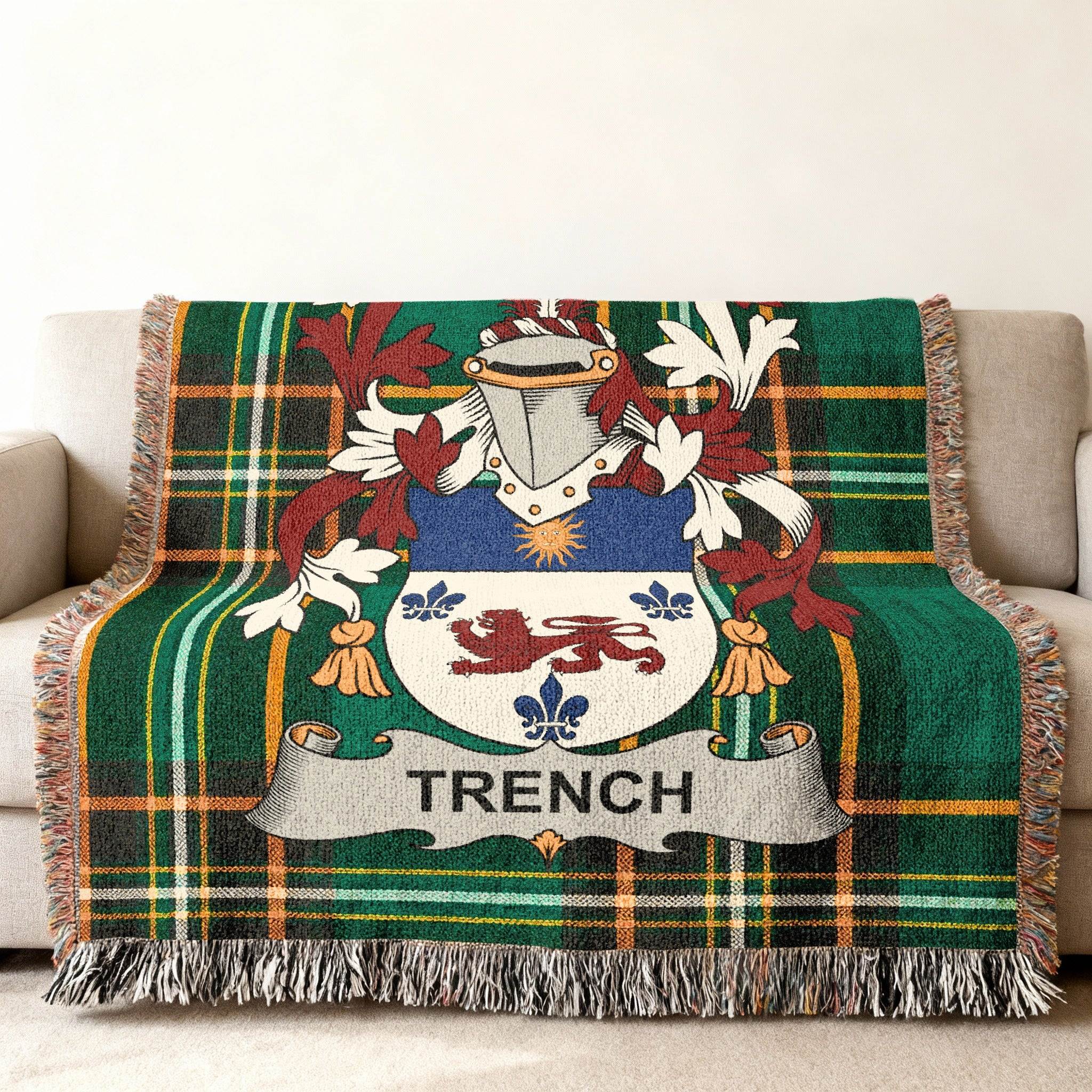 Trench family crest on a green tartan throw blanket with fringe.