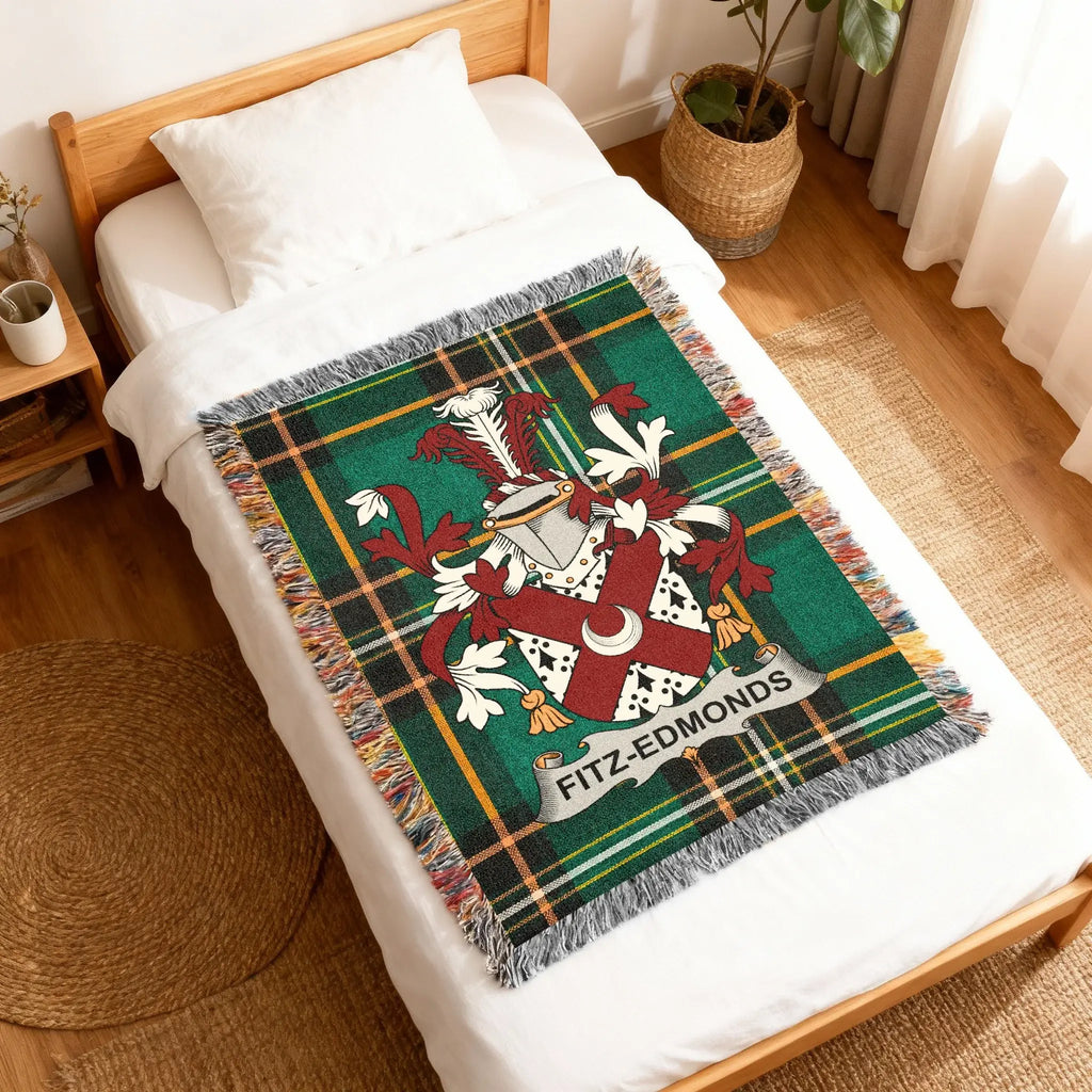 Green tartan blanket with Fitz-Edmonds family crest on a white bed.