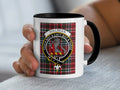 White mug with black rim and handle, featuring Macbean tartan and clan crest.