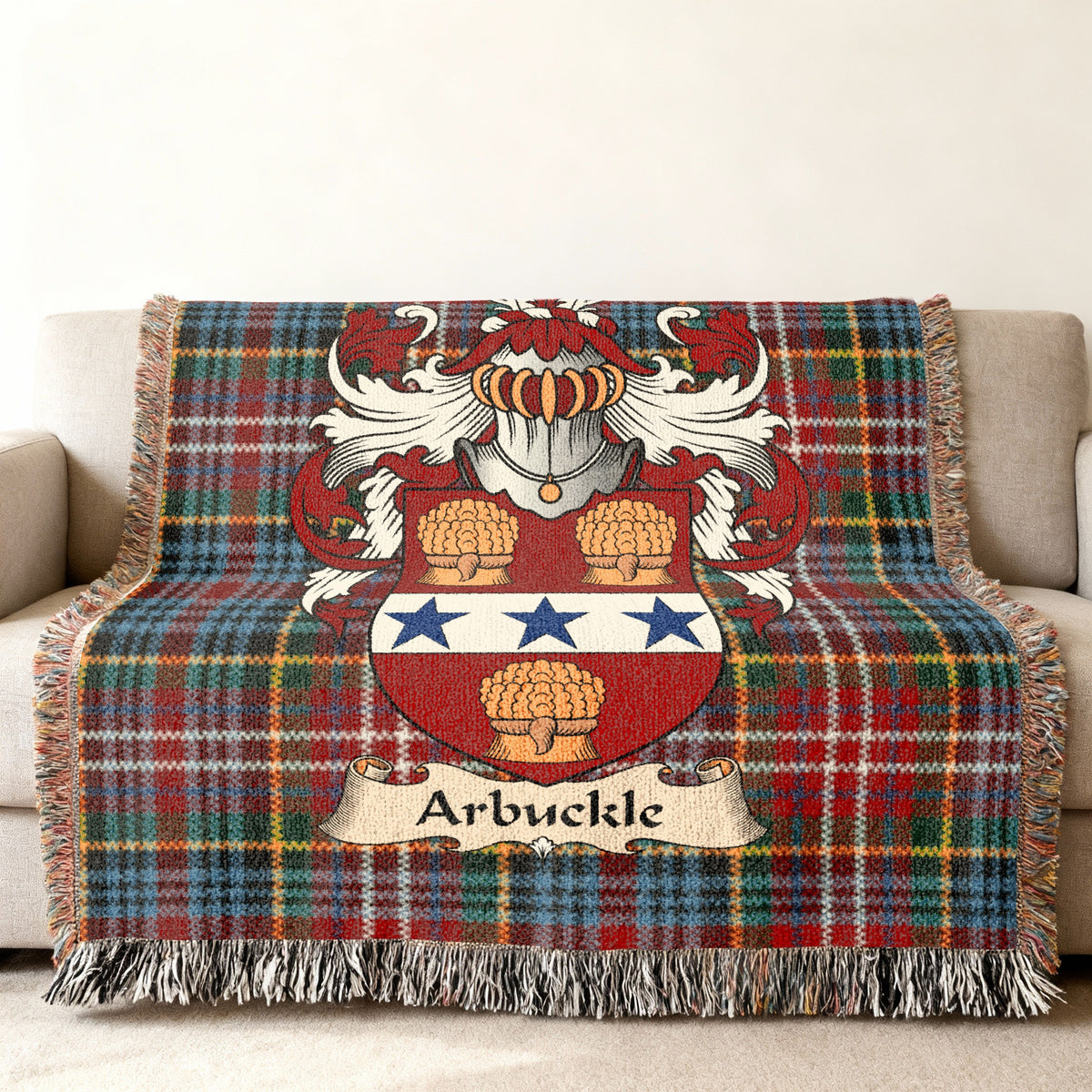 Arbuckle Scottish family shield woven blanket with Caledonia tartan background on a sofa
