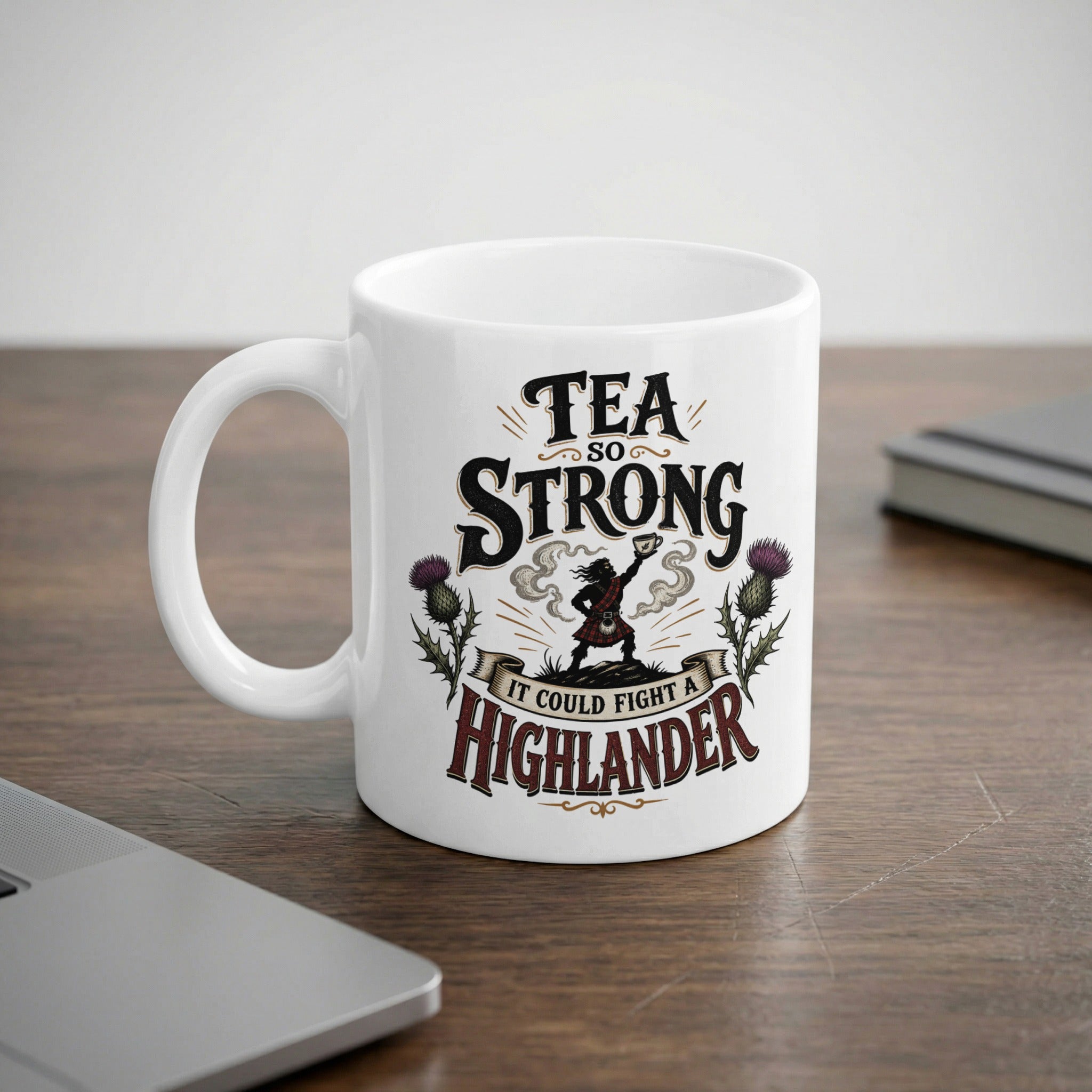 White mug with "Tea So Strong It Could Fight A Highlander" and thistle design.