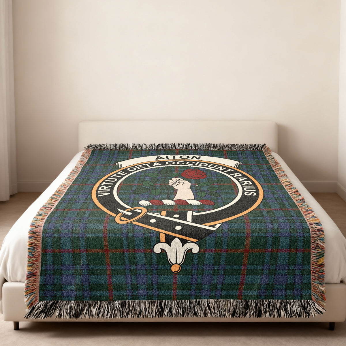 Aiton Scottish woven blanket spread across a bed, showing the full crest design and tartan background