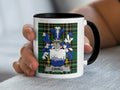 White mug with black handle featuring the Cahill family crest on a plaid background.
