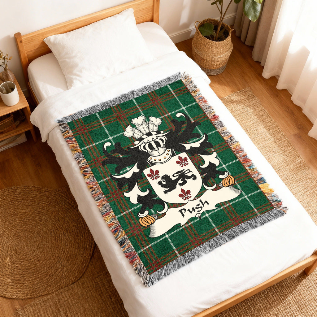 Green tartan blanket with crest and "Pugh" surname on a bed.