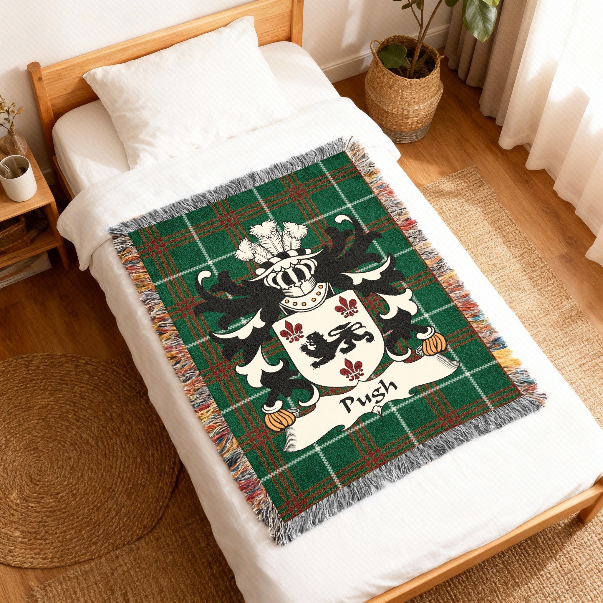 Green tartan blanket with crest and "Pugh" surname on a bed.