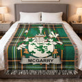 Green tartan blanket with McGarry crest displayed on a bed.