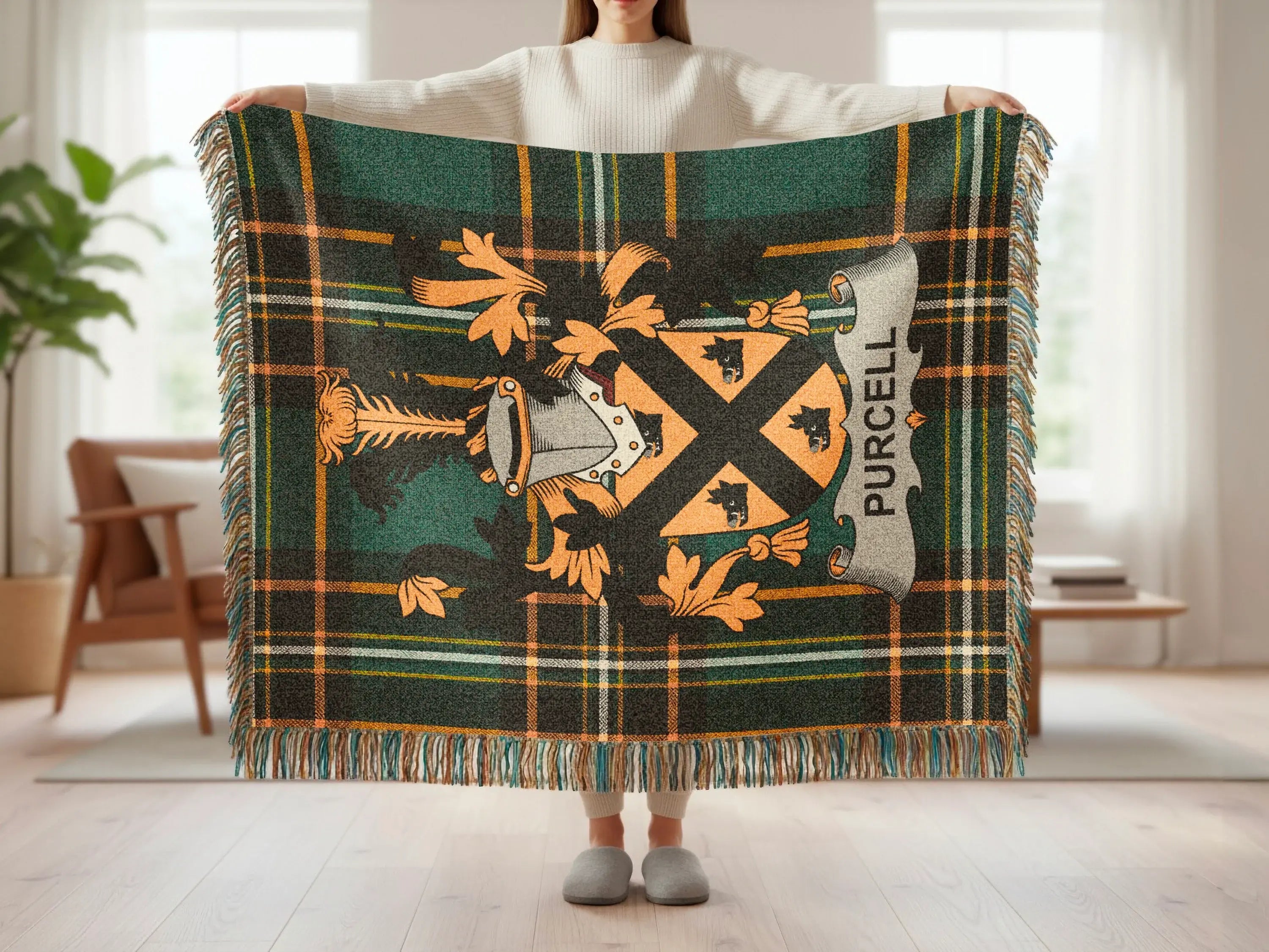 Tartan blanket featuring the Purcell crest and fringed edges held up by a person.