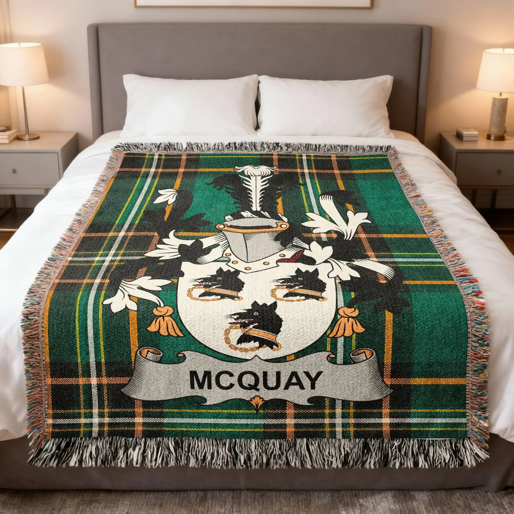 Green tartan blanket with McQuay family crest on a bed.