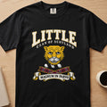 Little clan crest with gold cat face on a black Comfort Colors T-shirt, front view