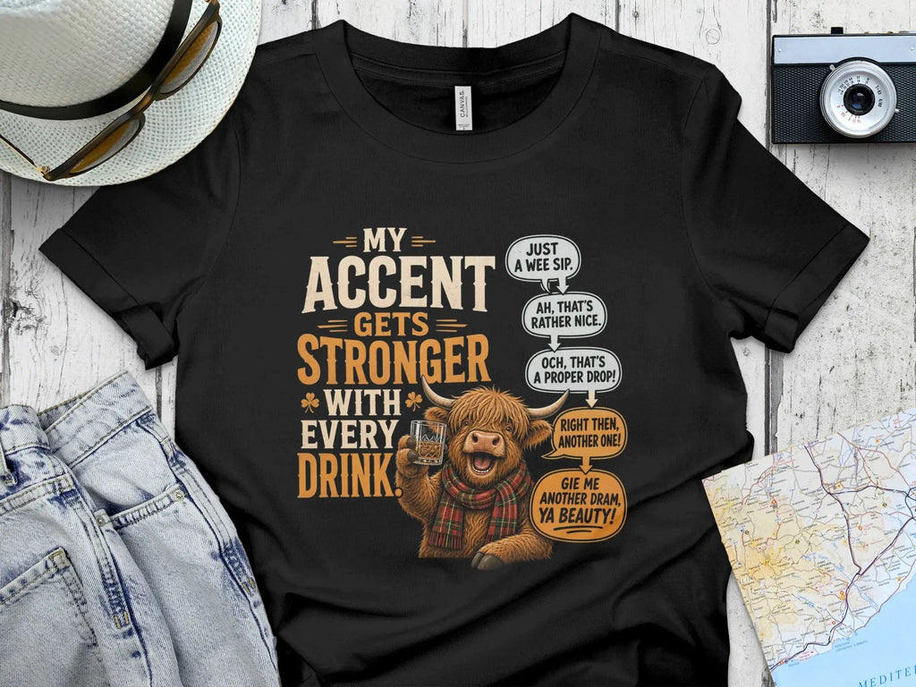 T-shirt with a Scottish Highland cow illustration and text about accents and drinks.