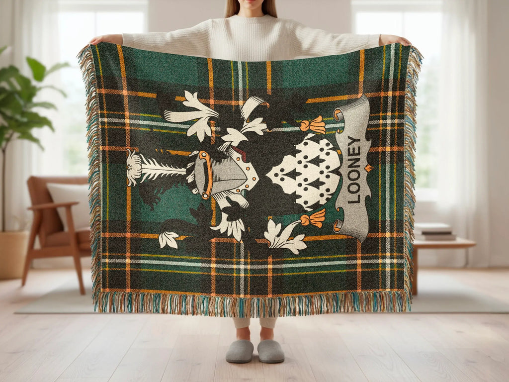Plaid blanket with Looney clan crest held up by a person.