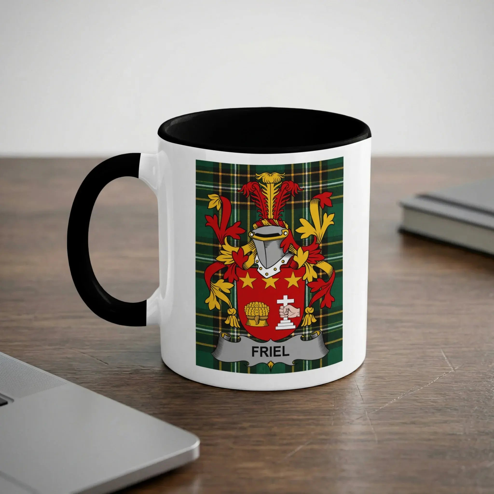 White mug with black rim featuring the Friel family crest on a plaid background.