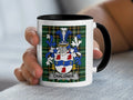 White mug with black rim, featuring the Chaloner family crest on a tartan background.