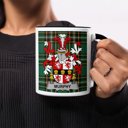 Mug with Murphy family crest on a tartan background, held by a person.