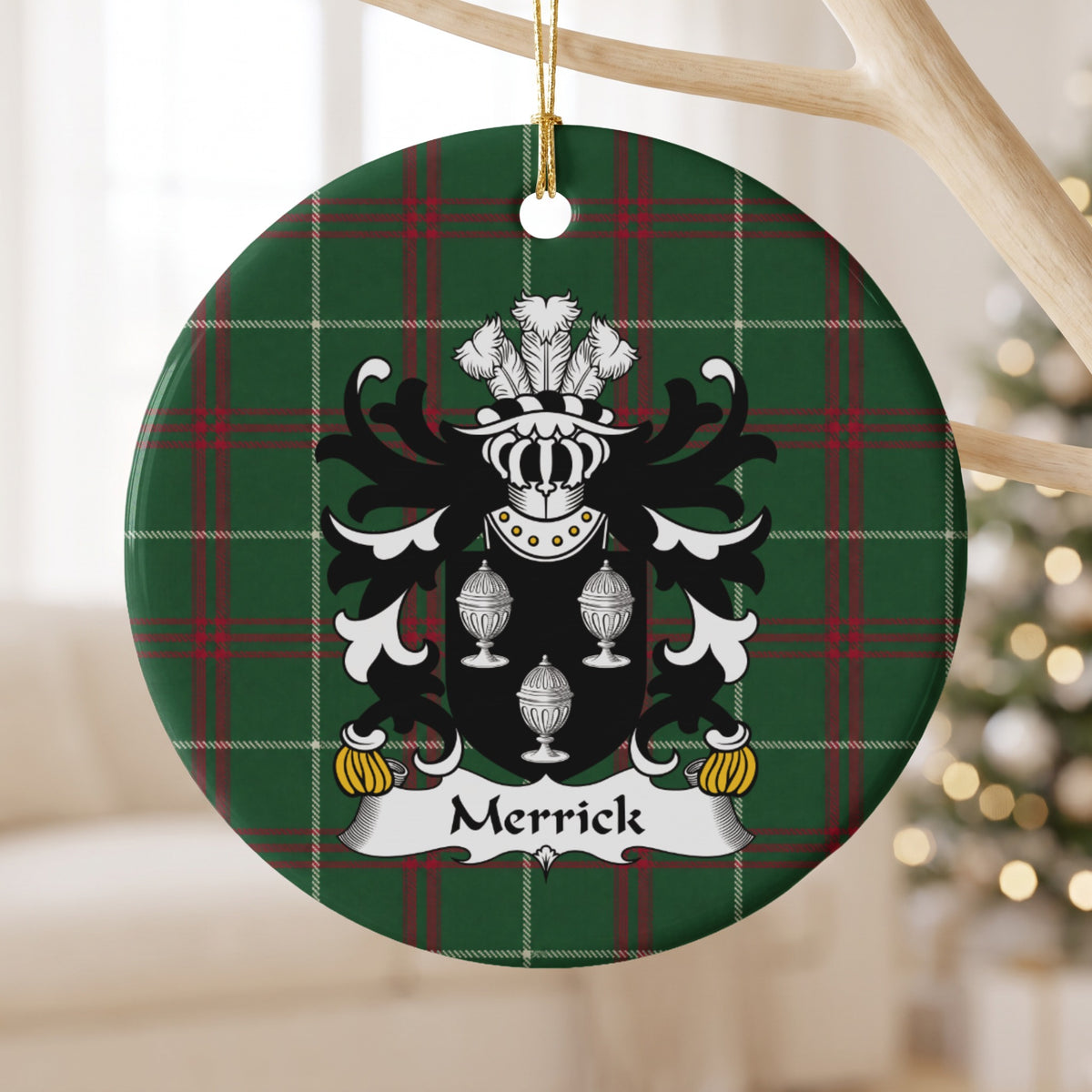 Merrick ornament hanging from a pale wooden branch; three white covered cups on a black shield on Welsh national tartan.