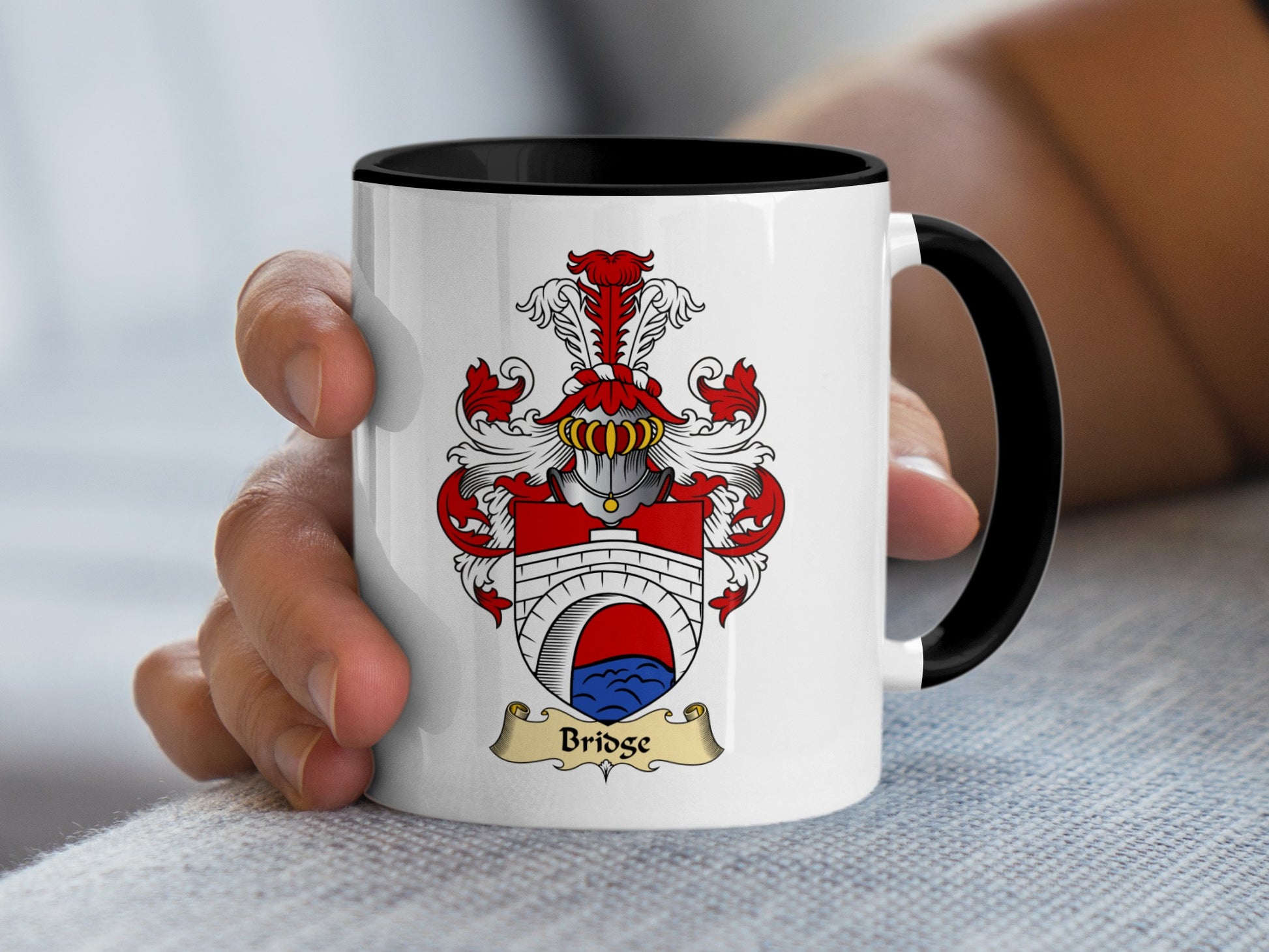 White mug with black rim featuring a coat of arms with the name "Bridge".
