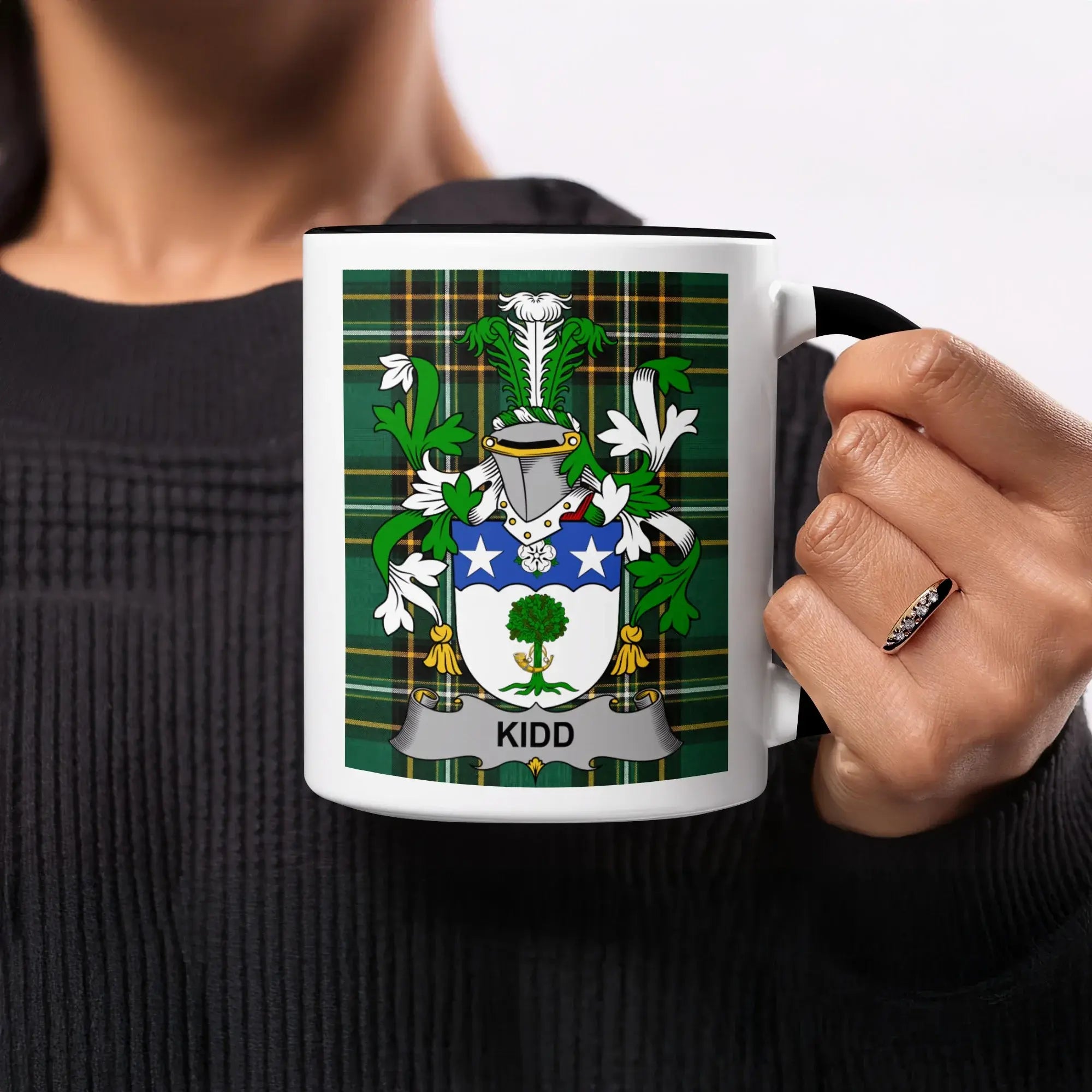 Kidd family crest on a white mug with a black rim.
