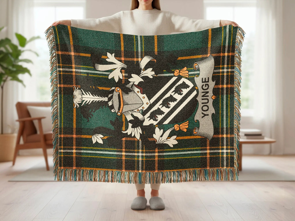 Tartan blanket with a family crest and "YOUNGE" text displayed by a person.