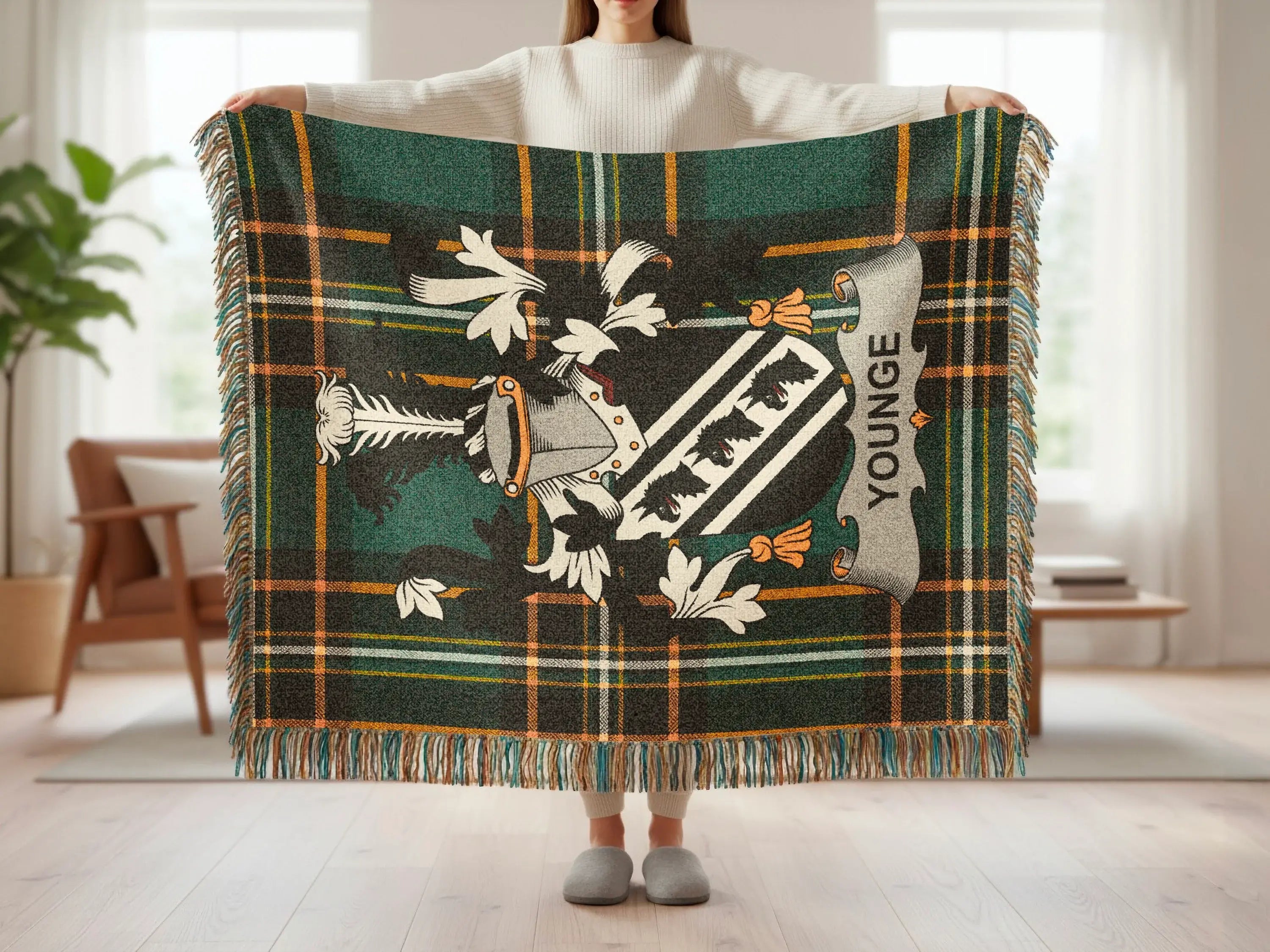 Tartan blanket with a family crest and "YOUNGE" text displayed by a person.
