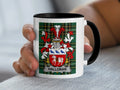 White mug with black handle featuring Halloran family crest on plaid background.