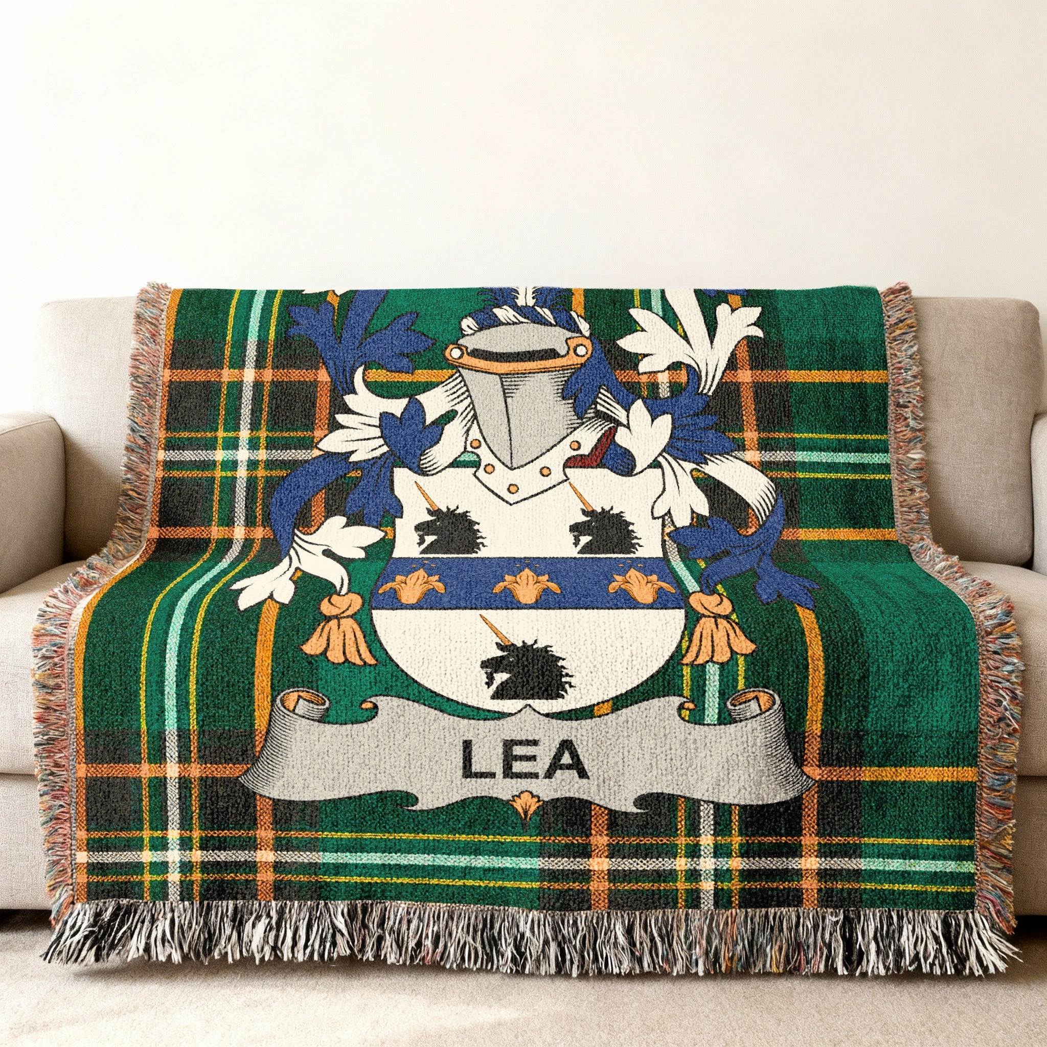 Plaid throw blanket with Lea family crest on a couch.