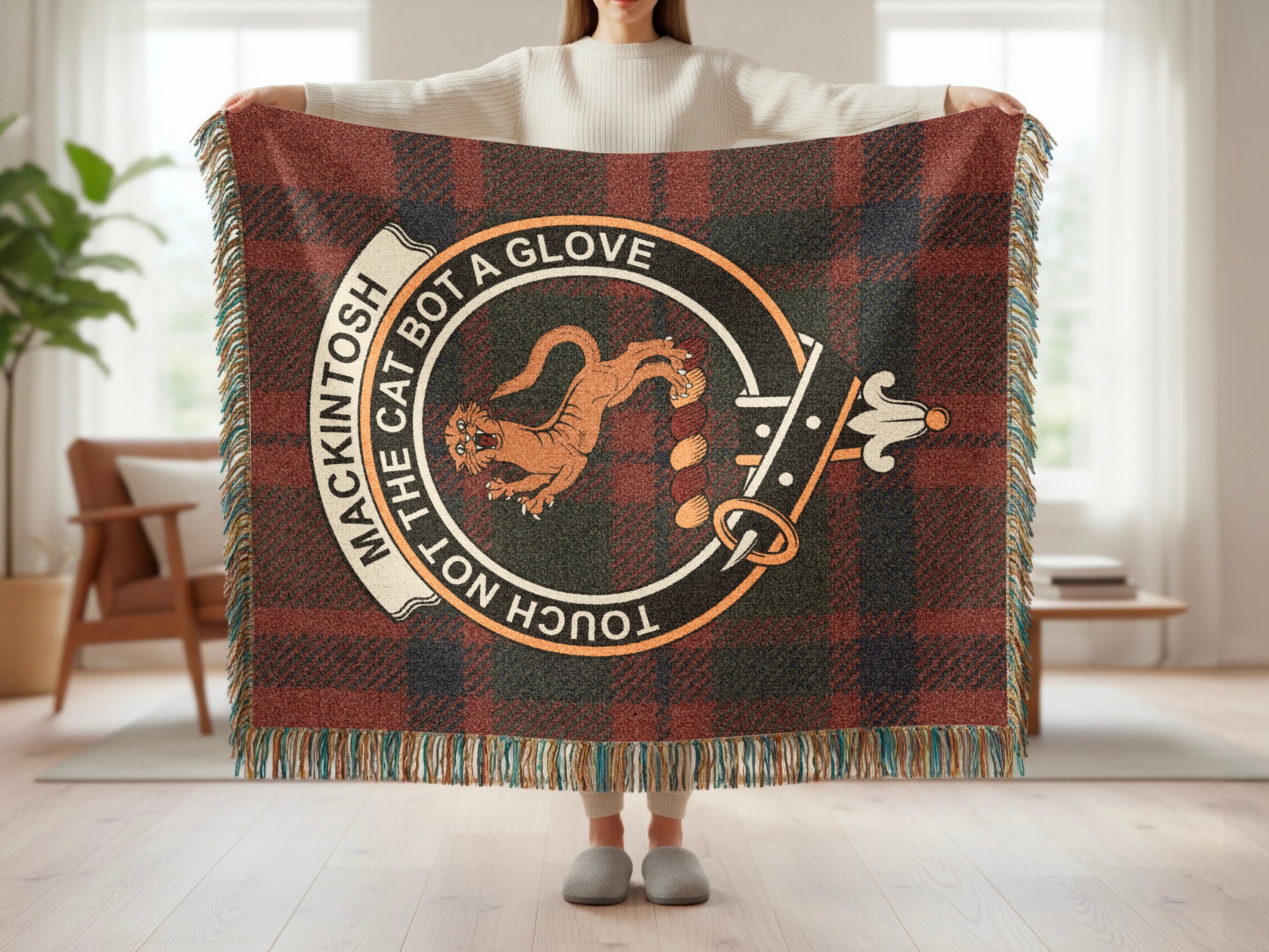 Mackintosh crest with Touch Not the Cat motto on tartan woven blanket