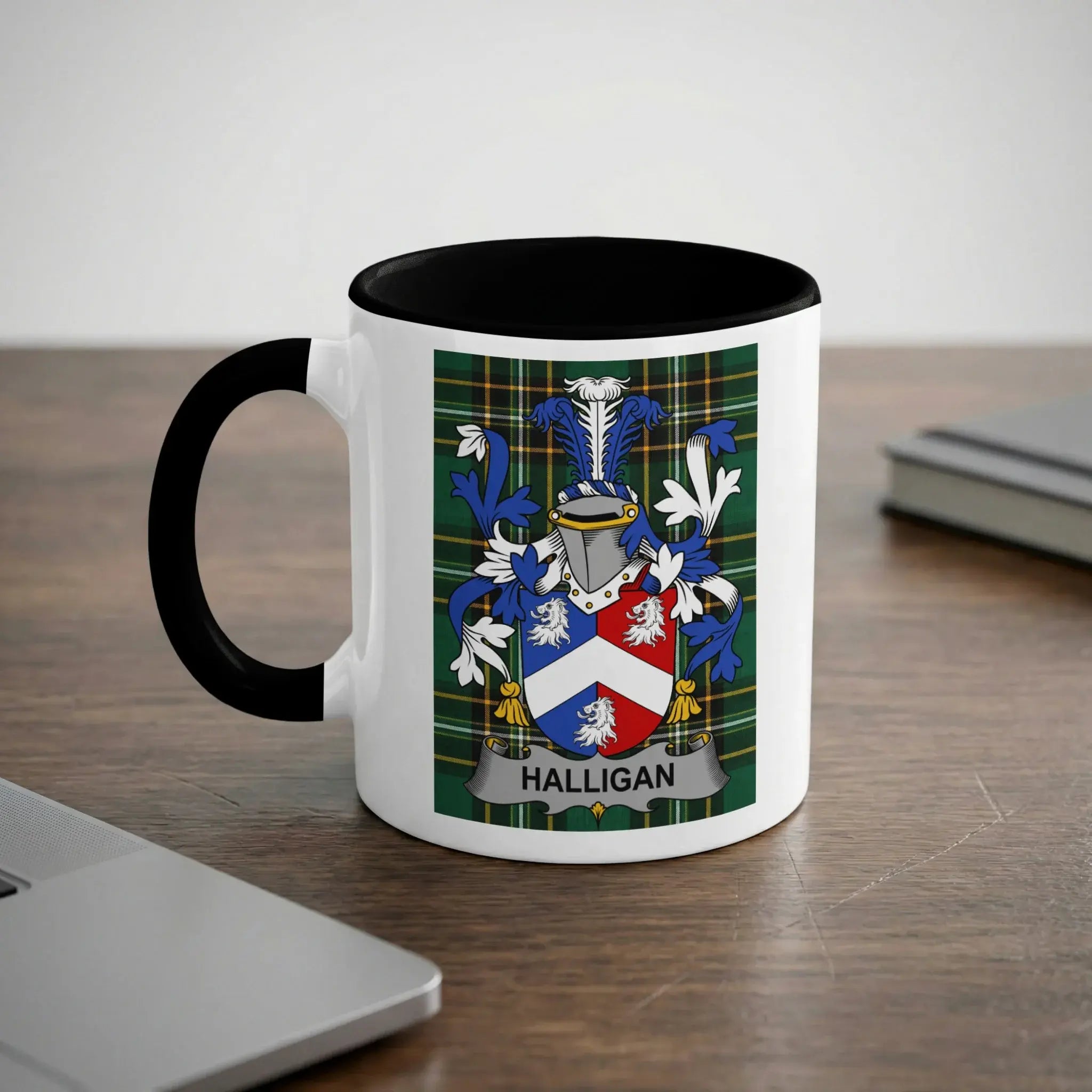 Mug with Halligan family crest on a desk next to a laptop.
